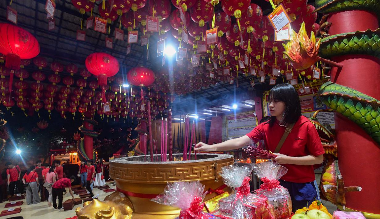 Ratusan jemaat datang silih berganti untuk melakukan sembahyang sebagai bentuk syukur atas rezeki dan doa untuk keselamatan di tahun mendatang. Tampak dalam foto, umat Khonghucu melakukan sembahyang pada malam Tahun Baru Imlek di Wihara Kwan In Thang, Pondok Cabe, Tangerang Selatan, Senin (16/2/2026). (merdeka.com/Arie Basuki)