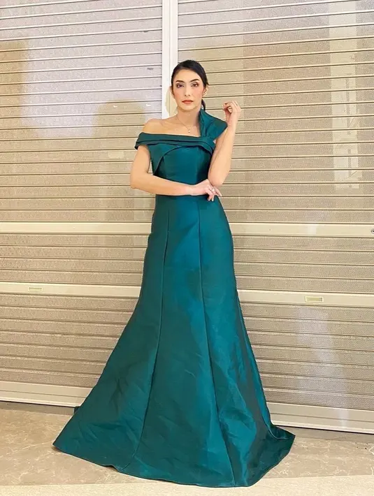 Masih dengan gaun berwarna hijau, Tyas Mirasih tampil dengan look yang glamor dengan gaun A-line. Sebagai gaun one off shoulder digunakan variasi aksen pita di bahu kiri.(instagram/tyasmirasih)