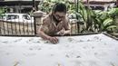 Pembatik disabilitas menyelesaikan karyanya di Rumah Batik Palbatu, Jakarta, Kamis (3/12/2020). Rumah Batik Palbatu mempercayakan kepada penyandang disabilitas binaannya untuk membuat kain batik, baik bercorak tradisional, temporer maupun perpaduan keduanya. (merdeka.com/Iqbal S. Nugroho)