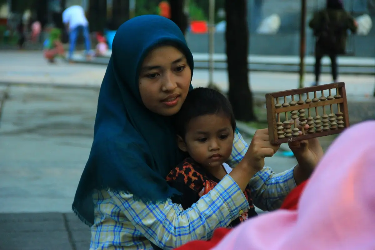 Lenny bersama kawan-kawannya saat mengajari anak-anak marginal membaca dan menulis sambil bermain (Dian Kurniawan/Liputan6.com)