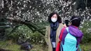Seorang wanita berfoto di taman botani Hangzhou, Provinsi Zhejiang, China (19/2/2020). Sebagai upaya pencegahan coronavirus baru, kawasan indah tersebut telah menetapkan batas jumlah pengunjung saat ini dan semua yang memasuki kawasan itu diwajibkan mengenakan masker. (Xinhua/Zheng Mengyu)