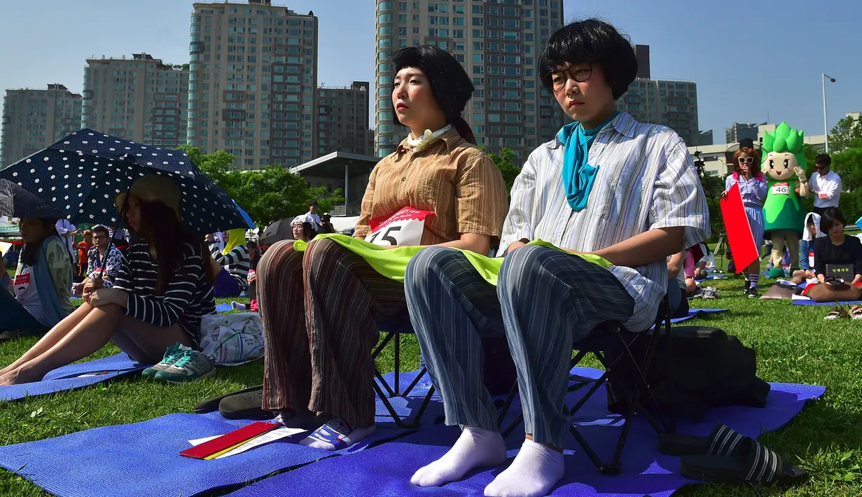 Seorang peserta ambil bagian dalam kompetisi bengong atau Space Out Competition di taman di Seoul, Korea Selatan, (22/5). Banyak dari peserta dilaporkan tertarik mengikuti kompetisi sebagai kesempatan untuk melepaskan diri dari stres. (Jung YEON - JE/AFP)