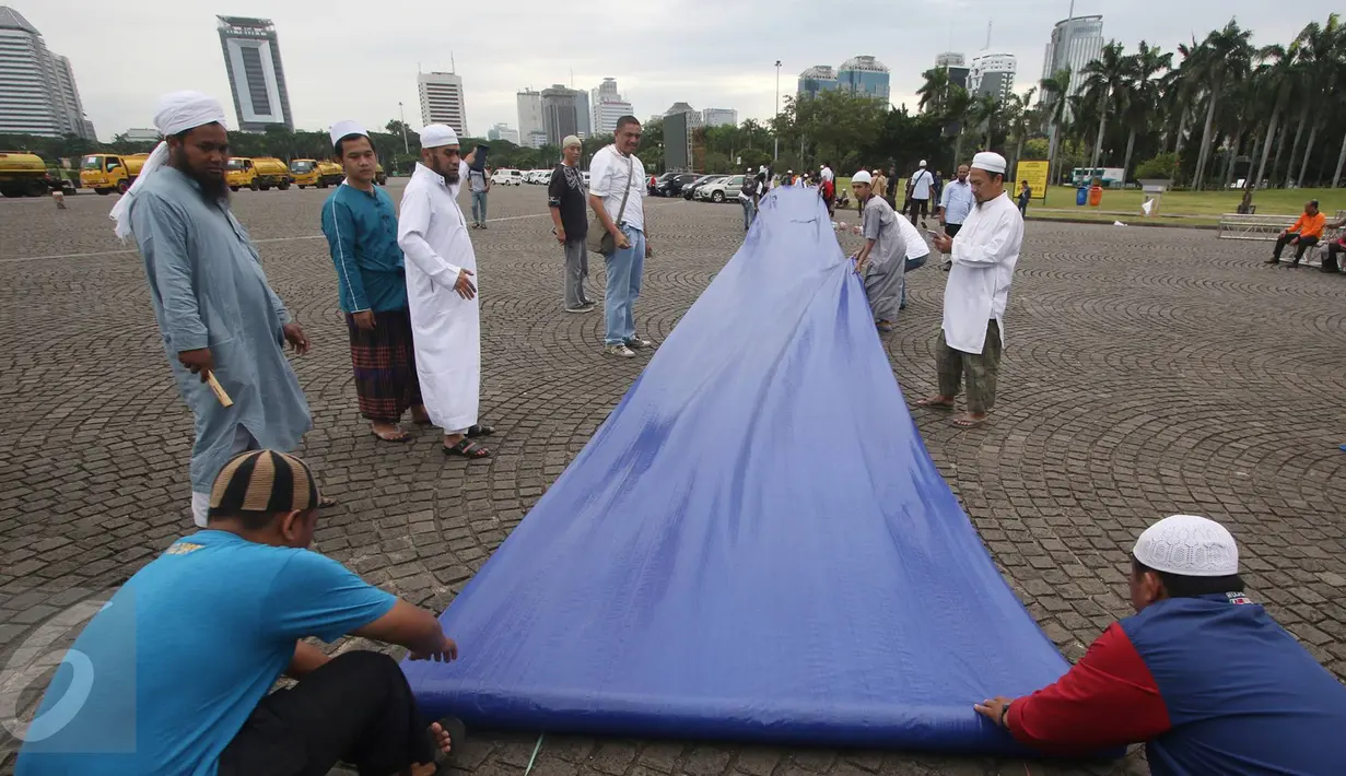 Warga mempersiapkan kelengkapan aksi damai 2 Desember di Monas, Jakarta, Kamis (1/12). Jelang aksi damai, sejumlah persiapan mulai dilakukan, seperti panggung, baris untuk Salat Jumat, hingga pengamanan dari kepolisian. (Liputan6.com/Immanuel Antonius)