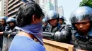 Polisi anti huru hara berjaga-jaga di depan Kedutaan Besar AS saat aksi protes berlangsung AS di Manila, Jumat (28/4). Demonstran mengecam imperealisme yang dilakukan oleh Amerika Serikat, Jepang dan China atas Asia Tenggara. (AP Photo / Bullit Marquez)