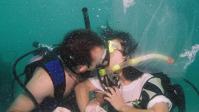 Sepasang kekasih berciuman saat merayakan Hari Valentine dengan berpartisipasi dalam pernikahan bawah laut di pulau Kradan di Trang, Thailand. (AFP)