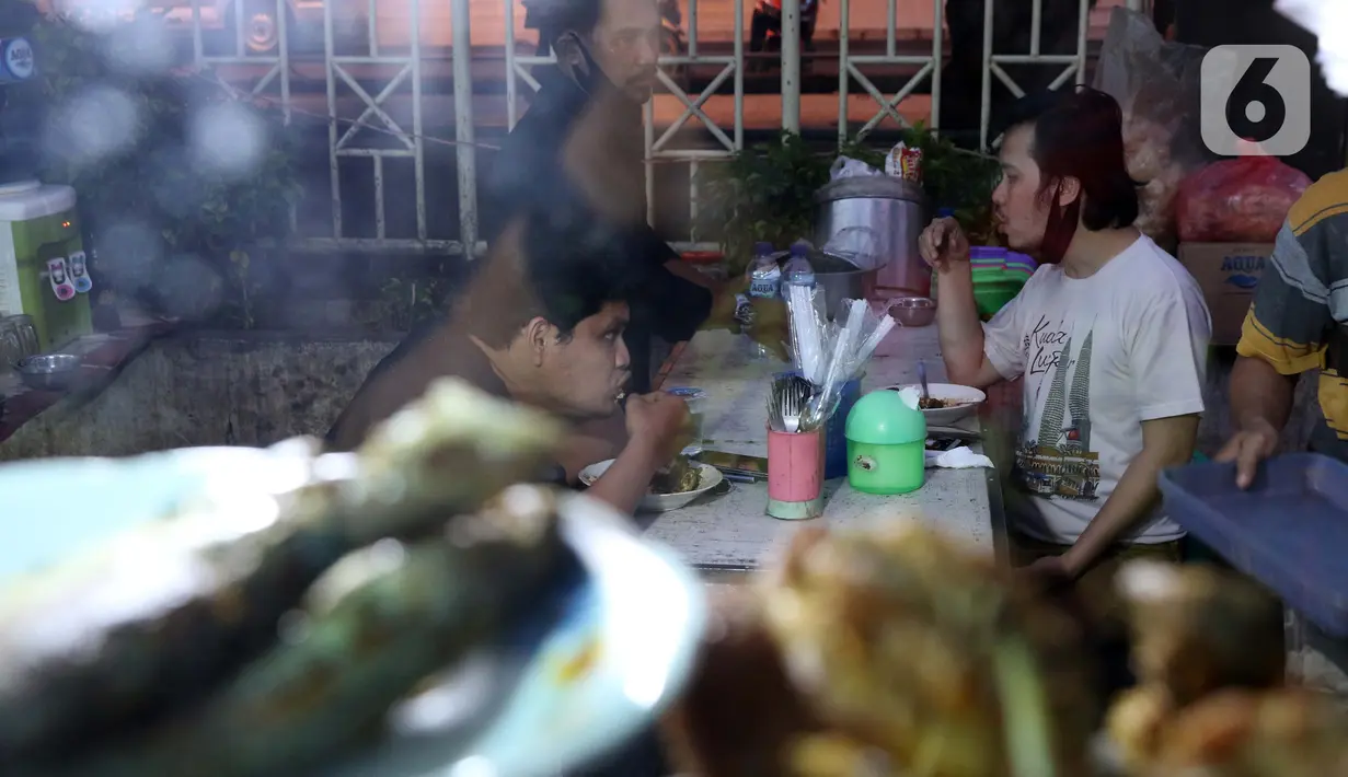 Warga berbuka puasa di kawasan Bendungan Hilir, Jakarta, Sabtu (25/4/2020). Meski ditengah pandemi virus Covid-19, masyarakat masih antusias berburu penganan berbuka puasa dengan tetap menerapkan pola jaga jarak dan memakai masker. (Liputan6.com/Helmi Fithriansyah)
