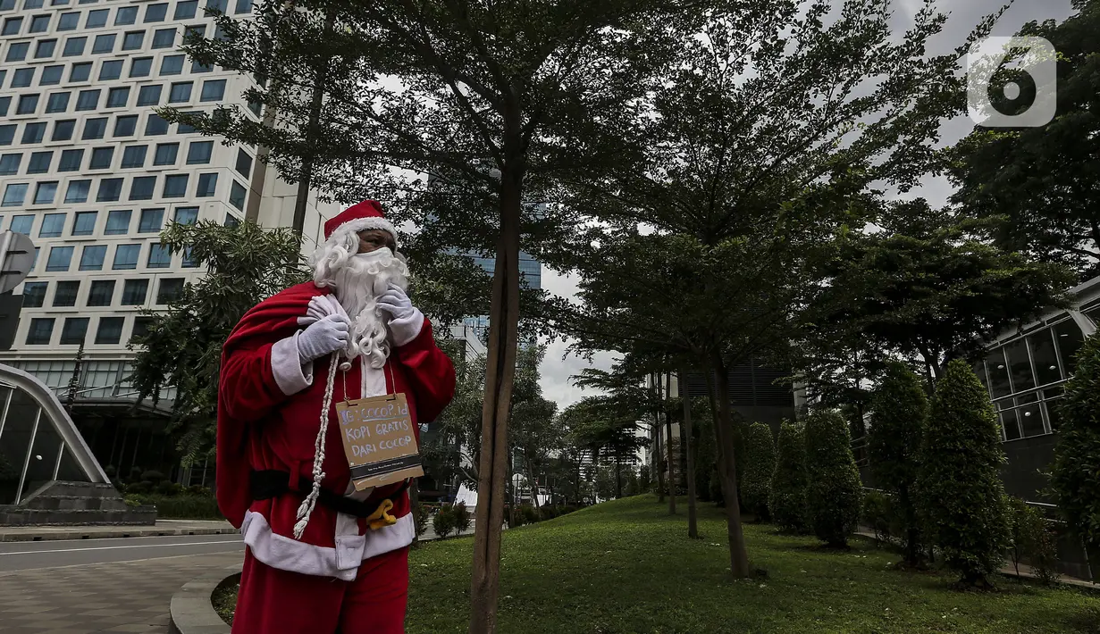 Pria berkostum Sinterklas berjalan saat membagikan kopi gratis kepada warga di kawasan Jalan Jenderal Sudirman, Jakarta, Sabtu (19/12/2020). Selain menyambut Natal, pembagian kopi tersebut juga untuk mempromosikan produk unggulan para petani di Indonesia. (Liputan6.com/Johan Tallo)