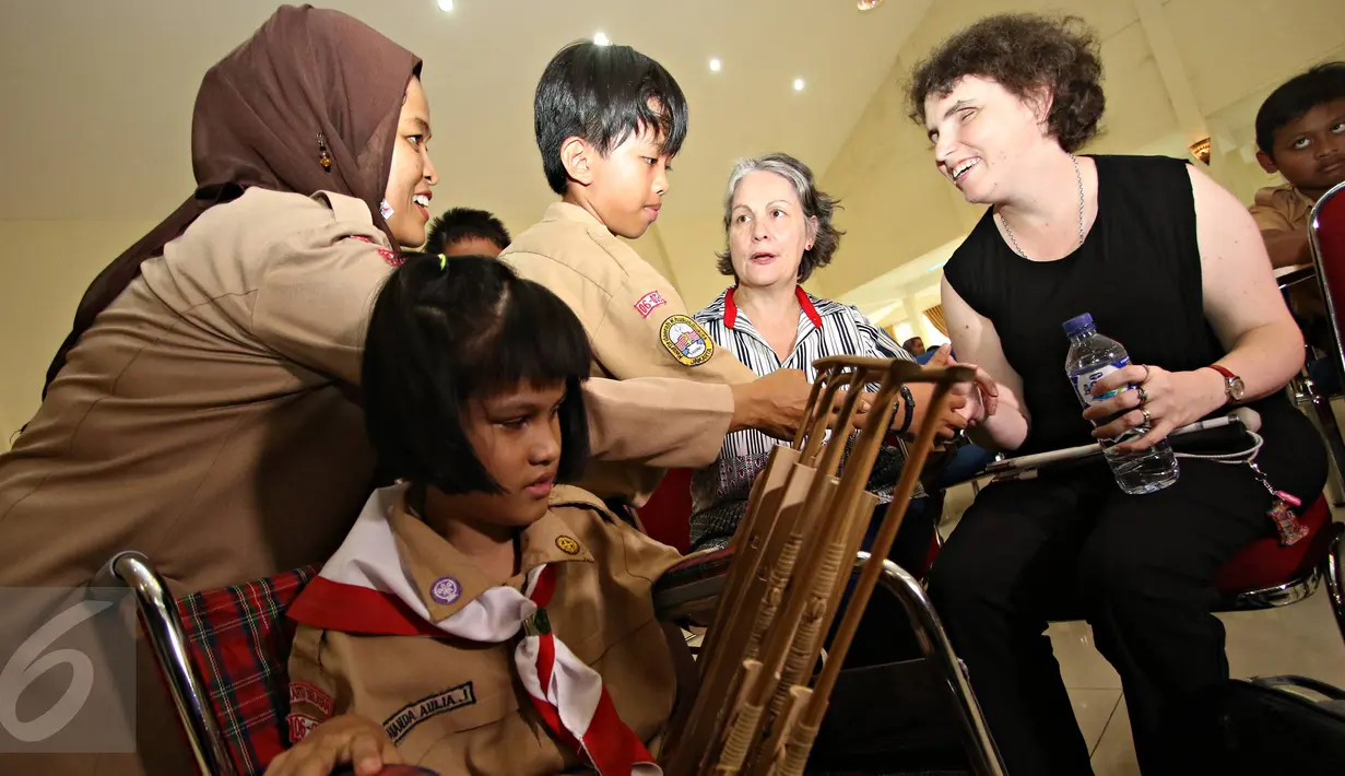 Murid bersalaman dengan Musisi tunanetra asal Australia saat acara Musik untuk Semua di SLB A Pembina, Jakarta, Rabu (2/12). (Liputan6.com/Immanuel Antonius)