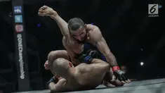 Petarung Rusia, Yusup Saadulaev (bawah) dan petarung Jepang, Masakazu Imanari saling menyerang pada pertarungan One Championship di Jakarta Convention Center (JCC), Sabtu (20/1). Pertarungan dimenangkan oleh Yusup Saadulaev. (Liputan6.com/Faizal Fanani)