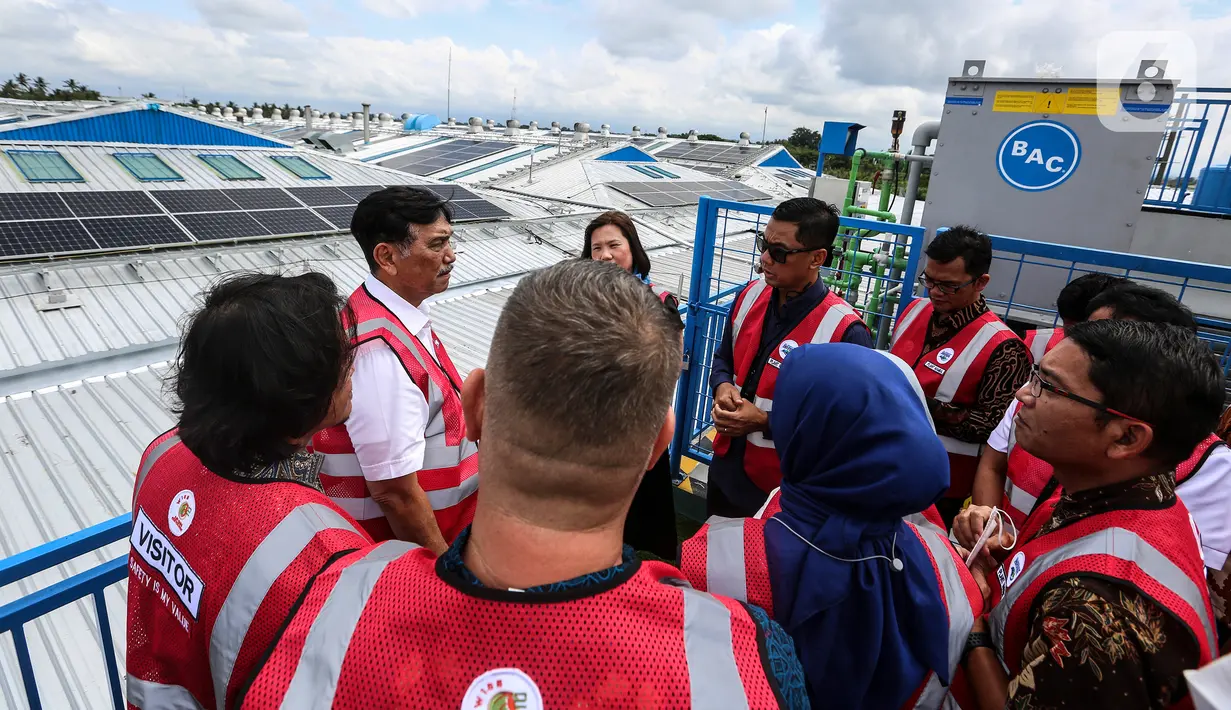 Menteri Koordinator Bidang Kemaritiman dan Investasi Luhut Binsar Pandjaitan (kedua kiri) berbincang dengan Direktur Utama PLN Darmawan Prasodjo saat menghadiri Peresmian PLTS Atap Pabrik Danone - Aqua Mambal di Badung, Bali, Rabu (31/8/2022). Acara tersebut kolaborasi antara PLN dan PT Tirta Investama guna mendukung energi hijau serta rangkaian memperkuat pelaksanaan G20 dalam transisi energi berkelanjutan. (Liputan6.com/Johan Tallo)
