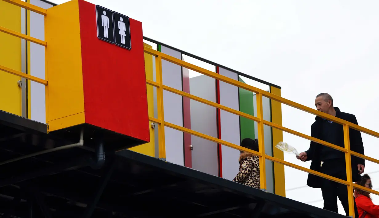 Sejumlah warga menggunakan toilet umum yang terletak di jembatan pejalan kaki setinggi 6 meter (19,7 kaki) di Chongqing, Tiongkok (23/2). Toilet ini pun tanpa atap di atasnya alias terbuka. (AFP Photo/China Out)