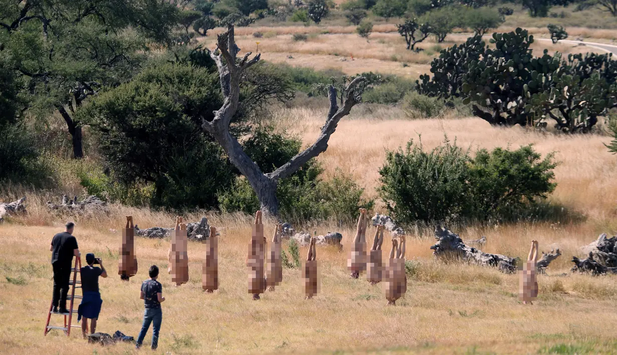 Sejumlah orang mengikuti instalasi seni 'Inversion', di wilayah San Miguel de Allende, Meksiko, Sabtu (28/10). Mereka berpose terbalik tanpa mengenakan busana. (REUTERS/Edgard Garrido)