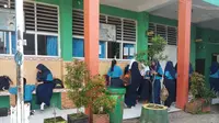 Para siswi SMPN 29 Makassar tampak mengenakan jilbab saat beraktifitas di sekolah (Liputan6.com/ Eka Hakim)