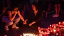 Dua wanita menangis saat memperingati gadis berusia 15 tahun Alexandra yang terbunuh di depan Kementerian Dalam Negeri Rumania di Bucharest (27/7/2019). Alexandra telah dibunuh setelah ia menelepon polisi tiga kali untuk melaporkan penculikannya dirinya.  (AFP Photo/Daniel Mihailescu)