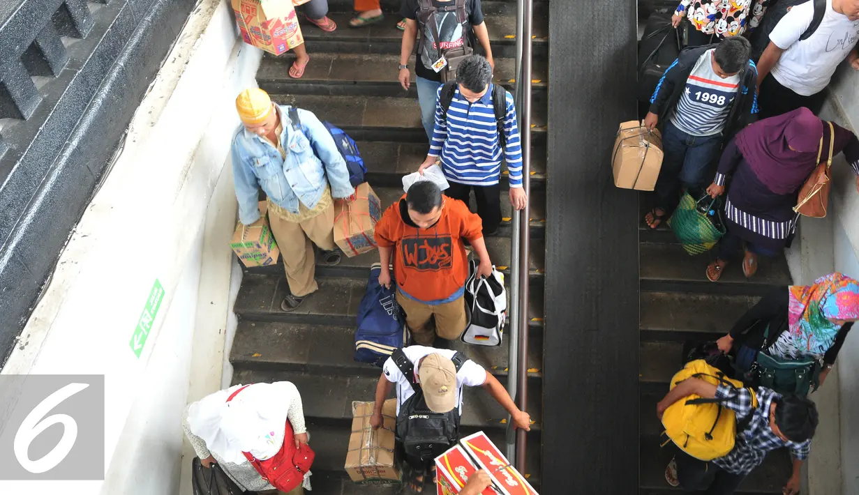 Para pemudik berjalan menuruni anak tangga saat tiba di Stasiun Senen, Jakarta, Senin, (20/7/2015). Dipredeksikan lonjakan arus balik tak hanya terjadi pada H+3 saja, kemungkinan akan kembali terjadi di H+8. (Liputan6.com/Herman Zakharia)