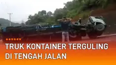 Sebuah truk kontainer terguling di tengah jalan saat menanjak mengundang perhatian.