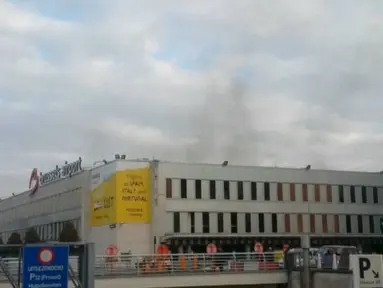 Asap hitam terlihat mengepul dari bandara Zaventem di Brussel, setelah terjadi ledakan, Belgia, Selasa (22/3). Sedikitnya 13 orang tewas akibat dua ledakan beruntun yang mengguncang ruang keberangkatan bandara tersebut. (REUTERS/Peter van Rossum)