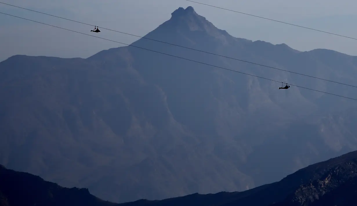 Wisatawan menikmati lintasan flying fox dari atas Gunung Jabel Jais Ras al-Khamiah di Uni Emirat Arab, 31 Januari 2018. Berada di ketinggian 1.249 meter, wahana zip-line ini diklaim memiliki jalur luncur terpanjang di dunia. (AP/Kamran Jebreili)