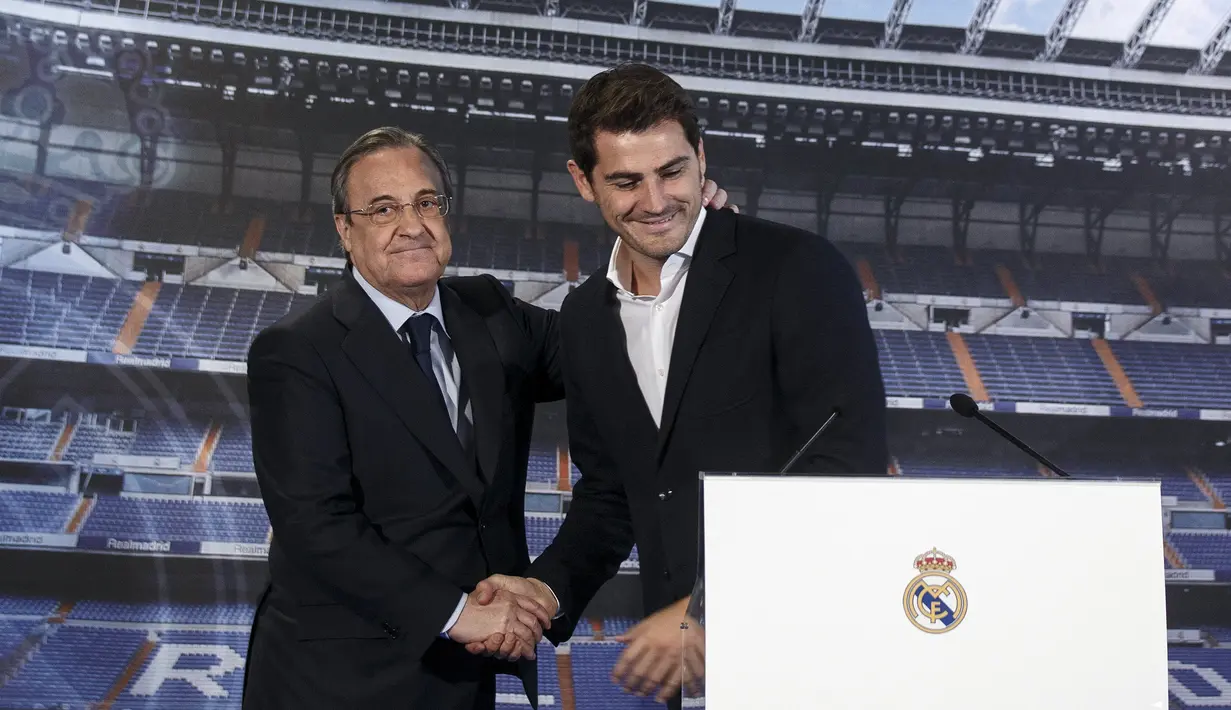 Mantan kiper sekaligus kapten Real Madrid Iker Casillas (kanan) bersalaman dengan Presiden Real Madrid Florentino Perez saat upacara perpisahannya di Stadion Santiago Bernabeu, Spanyol, Senin (13/7/2015). (REUTERS/Andrea Comas)