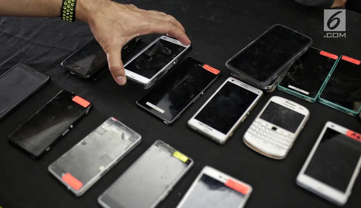Barang bukti handphone dalam kasus order fiktif pada transportasi online saat rilis di Polda Metro Jaya, Jakarta, Rabu (13/2). Polisi menyita 23 handphone, simcard, buku tabungan, kartu ATM. (Liputan6.com/Faizal Fanani)