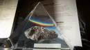 Batu dari Bulan terpajang dalam wadah kaca akrilik jelang perayaan 50 tahun misi Apollo di atas kapal USS Hornet, Alameda, California, Amerika Serikat, Selasa (16/7/2019). Hanya lima orang di dunia yang dapat secara rutin menangani batu berharga tersebut. (JOSH EDELSON/AFP)