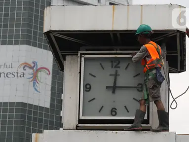 Petugas melakukan perawatan tugu jam yang berada di Merdeka Selatan, Jakarta, Minggu (2/2/2020). Perawatan tersebut dilakukan untuk pengecekan kondisi jam yang nantinya akan dipasangkan panel surya sebagai daya power agar tugu jam dapat berfungsi sebagai petunjuk waktu. (Liputan6.com/Angga Yuniar)