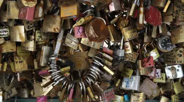 Gembok cinta yang sebelumnya terpasang di Jembatan Pont des Art saat dilelang oleh Ville de Paris, Prancis, Rabu (3/5). Ratusan gembok cinta itu akhirnya dilelang dan hasil dari penjualan akan disumbangkan ke pengungsi di Paris. (Jacques DEMARTHON/AFP)