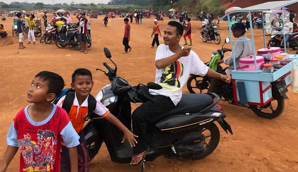 Warga menghabiskan waktu di tanah lapang kawasan Cipayung, Depok, Kamis (11/6/2020). Kurang tegasnya sanksi serta minimnya kesadaran masyarakat akan protokol kesehatan terkait covid-19 menyebabkan kawasan itu menjadi tempat berkerumun warga setiap sore hari. (Liputan6.com/Immanuel Antonius)