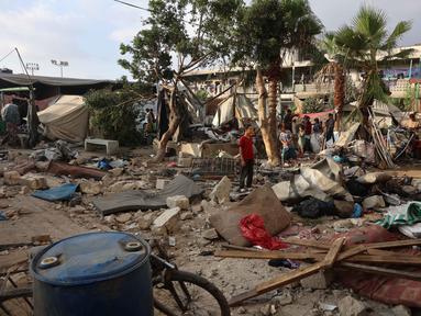 Pengungsi Palestina menyelamatkan sebagian barang-barang mereka di tengah puing-puing, di halaman Sekolah al-Farabi yang telah berubah menjadi tempat penampungan bagi para pengungsi, setelah diserang oleh serangan Israel, di Kota Gaza, bagian utara Jalur Gaza, pada 7 September 2025. (Omar AL-QATTAA/AFP)