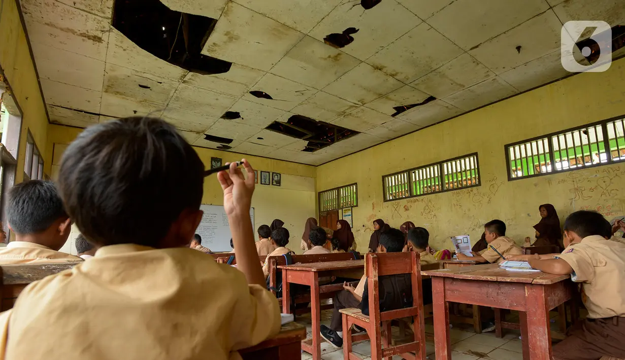 Murid SDN Samudrajaya 04 mengikuti proses belajar mengajar di Ruang Kelas 5, Desa Samudrajaya, Kecamatan Tarumajaya, Kabupaten Bekasi, Jawa Barat, Selasa (21/1/2020). Murid SDN Samudrajaya 04 terpaksa belajar di gedung sekolah yang rusak sejak tahun 2014. (merdeka.com/Imam Buhori)