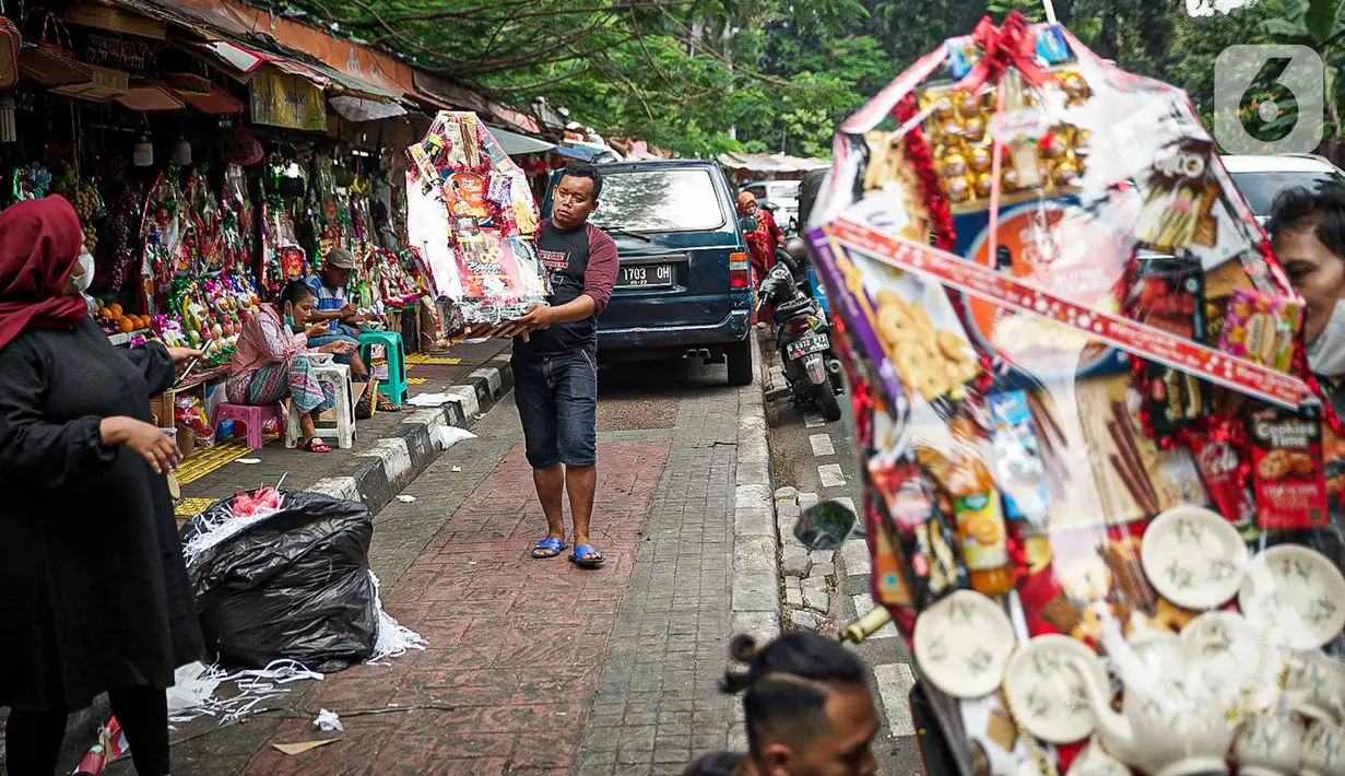 Pedagang membawa parsel yang siap kirim di Pasar Barito, Jakarta, Kamis (23/12/2021). Pedagang mengakui penjualan parsel sebagai hantaran Natal mulai ramai. Parsel yang paling banyak diminati adalah parsel makanan dengan harga mulai dari Rp 100.000 hingga Rp 800.000. (Liputan6.com/Faizal Fanani)