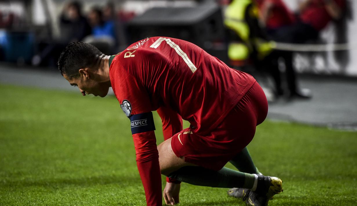 Bomber Portugal, Cristiano Ronaldo terkapar pada laga kedua kualifikasi Piala Eropa 2020 yang berlangsung di Stadion Da Luz, Lisbon, Senin (27/3). Portugal raih hasil imbang 1-1 kontra Serbia. (AFP/Patricia de Melo)
