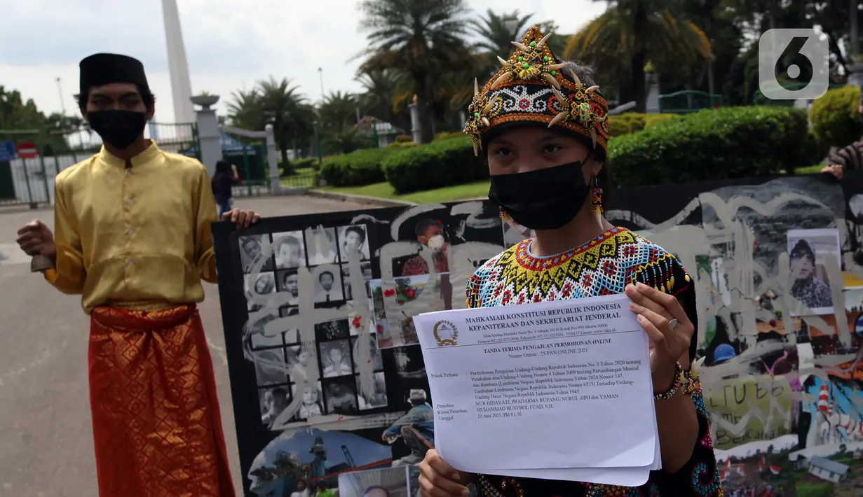 Demonstran melakukan aksi teatrikal saat unjuk rasa di kawasan Bundaran Patung Kuda Arjuna Wijaya, Jakarta, Senin (21/6/2021). Aksi yang dilakukan bertepatan dengan ulang tahun Presiden Joko Widodo ini sebagai bentuk kecaman dan penolakan terhadap revisi UU Minerba. (Liputan6.com/Angga Yuniar)