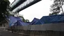 Petugas memeriksa kondisi box girder beton proyek light rapid transit ( LRT)  yang roboh di Kayu Putih, Jakarta Timur, Senin (22/1). Jalur yang roboh di tiang P28-P29 sudah ditutupi dengan terpal biru. (Liputan6.com/Arya Manggala)