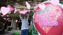 Seorang pria menghias simbol hati untuk Hari Valentine atau Hari Kasih Sayang di sebuah Tempat Pemungutan Suara (TPS) di Solo, Jawa Tengah, Selasa, 13 Februari 2024. (AP Photo/Achmad Ibrahim)