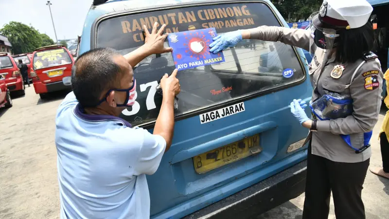 Seorang Polwan memasangkan stiker "Ayo Pakai Masker" ke angkutan umum. (Istimewa)