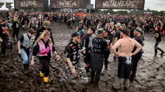 Penggemar musik metal menunggu pembukaan salah satu pintu masuk Wacken Open Air (WOA) di Wacken, Jerman, 2 Agustus 2023. (Christian Charisius/dpa via AP)
