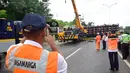 Sejumlah petugas berada di lokasi kejadian truk yang terguling di Ruas Tol  KM 10 Kota Semarang, Jawa Tengah, Senin (6/3). (Liputan6.com/Gholib)