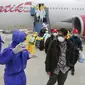 Petugas menyemprotkan cairan disinfektan ke WNI yang dievakuasi dari Wuhan, China saat tiba di bandara internasional Hang Nadim, Batam, Minggu (2/2/2020). Sebanyak 245 WNI di Wuhan dievakuasi ke Indonesia terkait merebaknya virus corona di kota tersebut. (Photo by Handout/Indonesian Embassy/AFP)