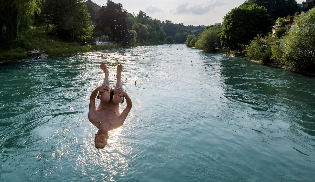 Seorang pemuda melompat ke Sungai Aare di Bern, Swiss, 21 Juni 2017. Menurut situs Britanica, Sungai Aare yang menjadi tempat tenggelamnya anak Gubernur Jawa Barat Ridwan Kamil, Emmeril Kahn Mumtadz atau Eril, memiliki panjang mencapai 295 kilometer. (Fabrice COFFRINI/AFP)