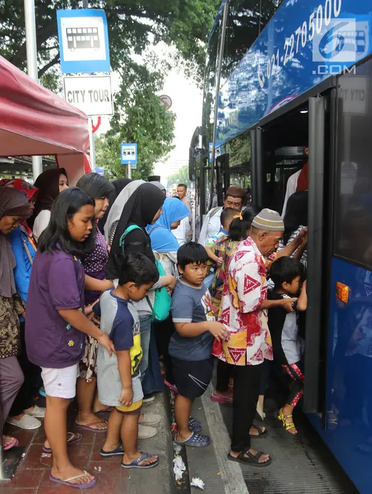 Warga menaiki bus tingkat wisata keliling Ibu Kota di kawasan Monas, Jakarta, Sabtu (16/6). Libur Hari Raya Idul Fitri dimanfaatkan oleh sebagian masyarakat Jakarta untuk berlibur ketempat wisata bersama keluarga. (Liputan6.com/Arya Manggala)
