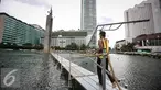 Pekerja membawa penyanggah di kolam Bundaran HI, Jakarta, Rabu (23/3). Pemasangan penyanggah bertujuan untuk menahan Tugu Selamat Datang dari getaran saat Bor Antareja proyek Mass Rapid Transit (MRT) melintas dibawahnya. (Liputan6.com/Faizal Fanani)