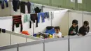 Sejumlah anak berdiri di ruang tidur bagi para migran yang didirikan di dalam hanggar bekas bandara Tempelhof di Berlin, Jerman, Rabu (9/12/2015). Jerman menerima satu juta migran dari beberapa negara yang sedang dilanda perang. (REUTERS/Fabrizio Bensch)