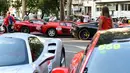Sejumlah pengunjung melihat mobil Ferrari yang dipamerkan saat perayaan ulang tahun Ferrari ke-70 di Corso Sempione di Milan, Italia (8/9). (AFP Photo/Miguel Medina)