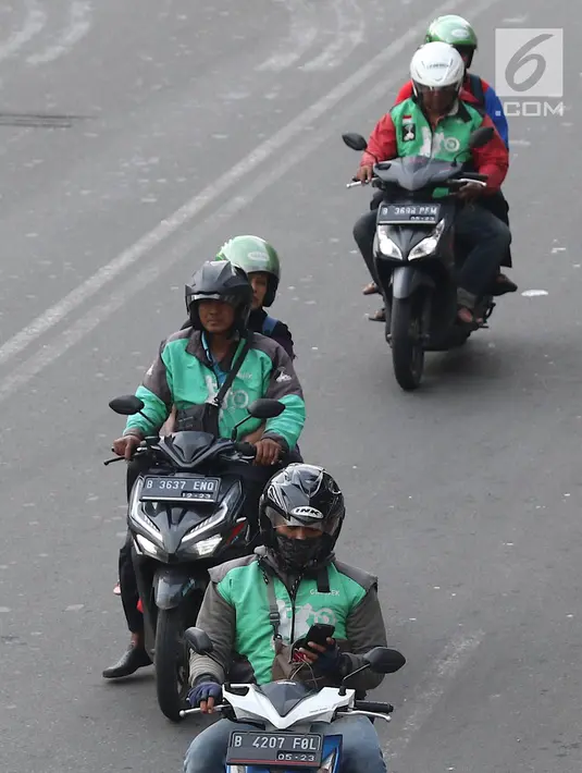 Pengendara sepeda motor mengoperasikan gawainya saat berkendara di Jakarta, Jumat (8/2). Menggunakan GPS saat berkendara dianggap melanggar UU Nomor 22 Tahun 2009 tentang Lalu Lintas dan Angkutan Jalan. (Liputan6.com/Immanuel Antonius)