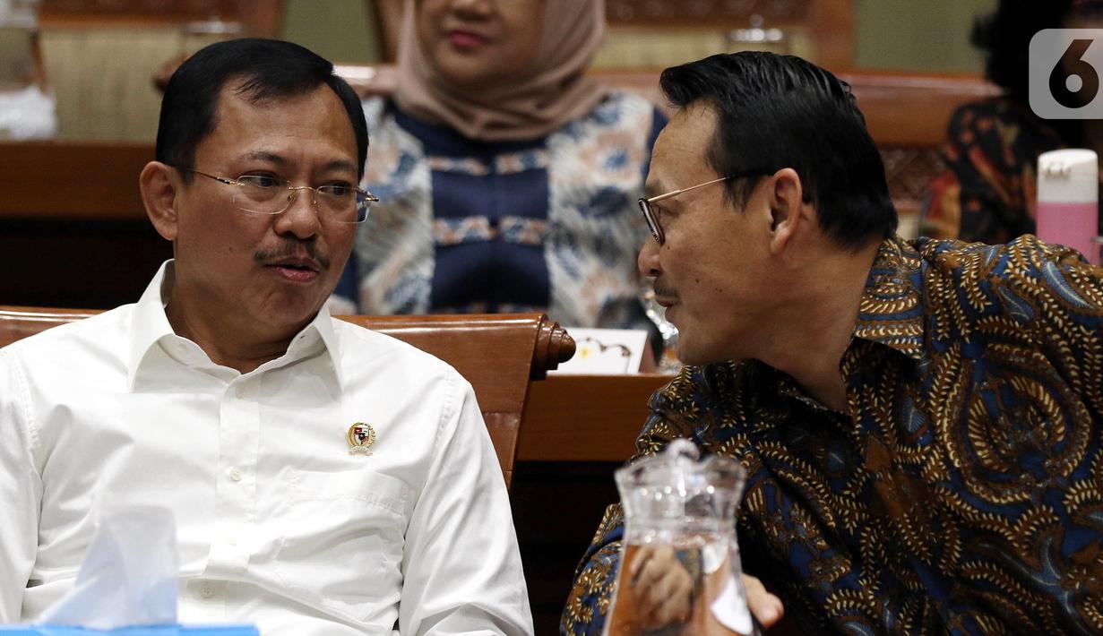 Menteri Kesehatan Terawan Agus Putranto (kiri) berbincang dengan Dirut BPJS Kesehatan Fachmi Idris (kanan) saat rapat dengar pendapat dengan Komisi IX DPR di Kompleks Parlemen, Jakarta, Selasa (5/11/2019). Rapat membahas polemik kenaikan iuran BPJS Kesehatan. (Liputan6.com/JohanTallo)