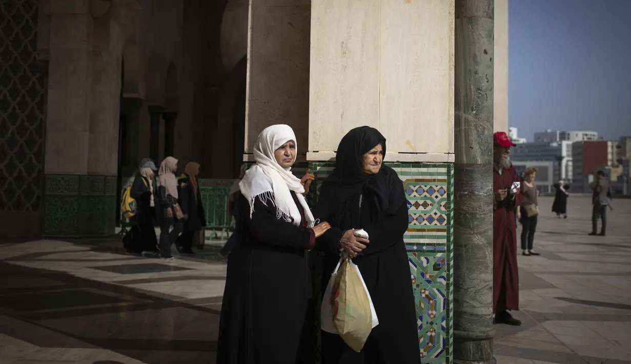 Wanita Muslim menunggu setelah melaksanakan salat di masjid Hassan II di Casablanca, Maroko (7/2/2020). Masjid ini dibangun menjorok ke samudra Atlantik membuatnya terlihat seakan akan berada di tengah laut layaknya sebuah masjid yang benar benar terapung. (AP Photo/Mosaab Elshamy)