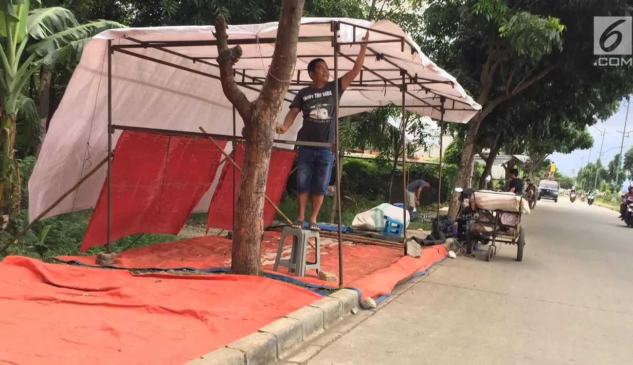 PKL memasang tenda untuk berdagang di Jalur Inspeksi Kanal Banjir Timur, Jakarta, Rabu (3/1). Kurangnya pengawasan menyebabkan jalur inspeksi tersebut dipenuhi PKL sehingga mengganggu ketertiban umum. (Liputan6.com/Immanuel Antonius)