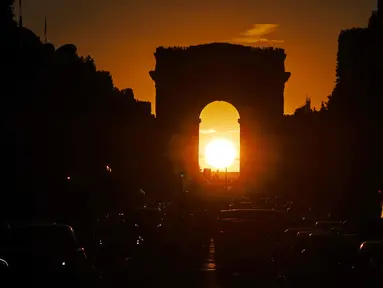 Foto yang diambil pada 2 Agustus 2022 menunjukkan Arc de Triomphe saat matahari terbenam, di Paris. Peristiwa yang dikenal sebagai "Paris Henge" ini terjadi dua kali setahun. (Photo by Stefano RELLANDINI / AFP)