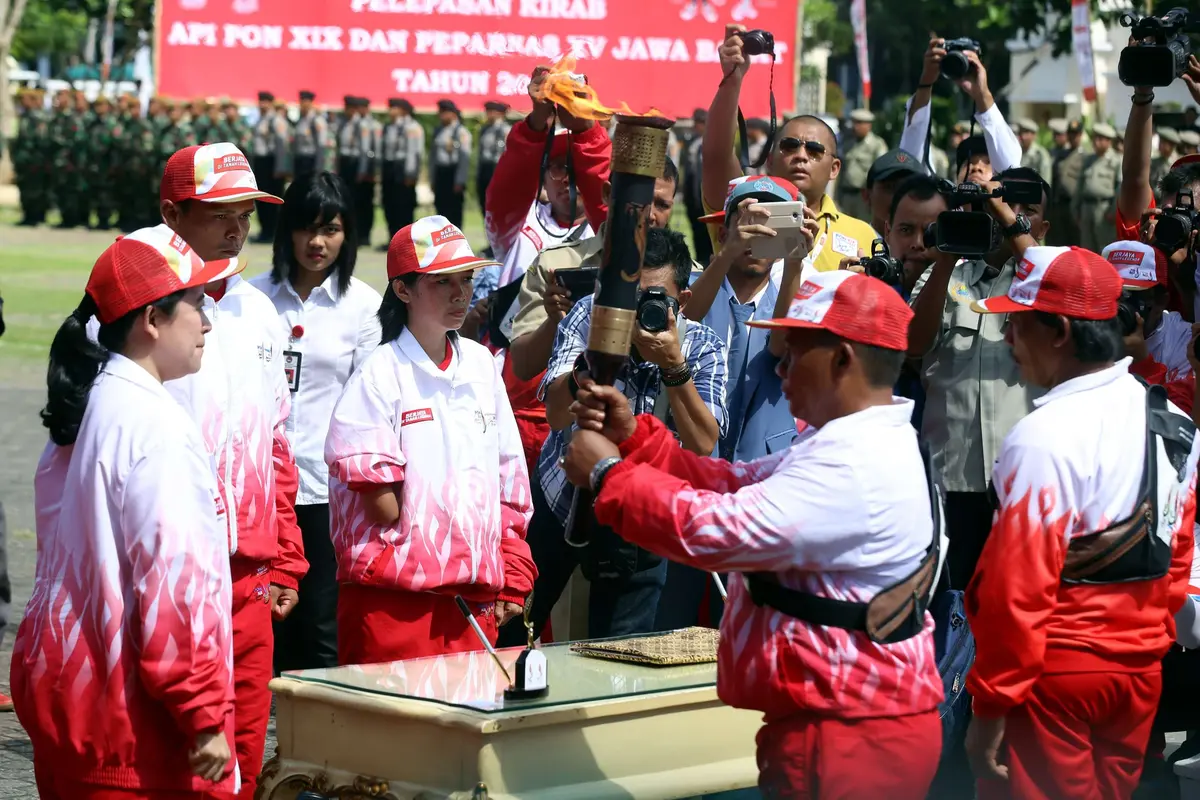  MenterKoordinator Bidang Pembangunan Manusia dan Kebudayaan (Menko PMK) Puan Maharani, mengambil dan melepas api PON